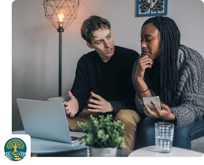 Two men discussing work in a cozy office with a laptop.
