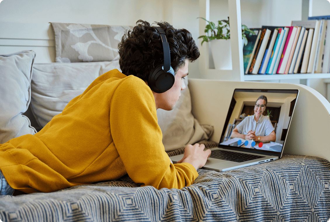 Young man video chatting with a woman on a laptop.